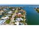 Aerial view of the waterfront home with a pool and dock, surrounded by lush landscaping at 527 Key Royale Dr, Holmes Beach, FL 34217