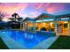 Twilight shot of backyard featuring a pool, patio, outdoor seating, and lush landscaping for serene relaxation at 527 Key Royale Dr, Holmes Beach, FL 34217