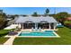 Beautiful backyard with a sparkling pool, outdoor seating, and lush greenery, perfect for relaxing and entertaining guests at 527 Key Royale Dr, Holmes Beach, FL 34217