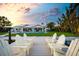 Gorgeous backyard featuring a waterfront view, patio, pool, and dock with ample seating for relaxing and entertaining guests at 527 Key Royale Dr, Holmes Beach, FL 34217