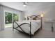 Bright bedroom with a black metal bed frame, white linens, and a large window at 527 Key Royale Dr, Holmes Beach, FL 34217