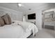 Bright bedroom featuring a large television, white linens, and a view of the bathroom at 527 Key Royale Dr, Holmes Beach, FL 34217