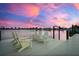 Relaxing waterfront scene featuring a private dock with Adirondack chairs for enjoying serene sunsets at 527 Key Royale Dr, Holmes Beach, FL 34217
