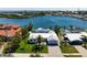 Waterfront property features a pristine white exterior, lush green lawn, and a private boat dock for direct water access at 527 Key Royale Dr, Holmes Beach, FL 34217