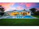 Exterior home view at sunset with beautiful pool and outdoor entertainment area at 527 Key Royale Dr, Holmes Beach, FL 34217