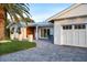 Beautiful home with a well-manicured lawn, paver driveway, and a modern garage door, showing curb appeal at 527 Key Royale Dr, Holmes Beach, FL 34217