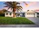 Beautiful single-story home with mature palm tree, well-maintained lawn, and brick driveway at 527 Key Royale Dr, Holmes Beach, FL 34217