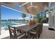 Charming outdoor dining area with a large wooden table, seating for eight, and waterfront views at 527 Key Royale Dr, Holmes Beach, FL 34217