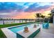 Stunning waterfront pool at sunset, complete with lounge chairs, lush landscaping, and breathtaking water views at 527 Key Royale Dr, Holmes Beach, FL 34217