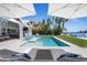 Resort-style pool area with lounge chairs, umbrellas, and a covered patio for relaxation and outdoor enjoyment at 527 Key Royale Dr, Holmes Beach, FL 34217