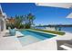 Gorgeous pool overlooking the water with lounge chairs and lush tropical landscaping at 527 Key Royale Dr, Holmes Beach, FL 34217