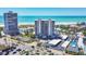 Stunning aerial view of the condo building, beach, and tennis courts on a sunny day at 5300 Ocean Blvd # 202, Sarasota, FL 34242