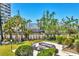 Outdoor lounge area with comfortable seating, mature trees, and manicured landscaping offering serene views at 5300 Ocean Blvd # 202, Sarasota, FL 34242
