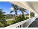 Covered porch view showcasing lush greenery and a waterway with palm trees in the distance at 5307 22Nd W Ave, Bradenton, FL 34209