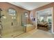 Luxurious bathroom featuring a glass enclosed walk-in shower and separate tub with easy access to the main bedroom at 5329 Trails Bend Ct, Sarasota, FL 34238