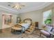 Beautiful bedroom featuring high tray ceilings, wood floors, ensuite bathroom, and a platform bed with stairs at 5329 Trails Bend Ct, Sarasota, FL 34238