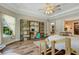 Spacious bedroom offers a study area, wood floors, a ceiling fan, and direct access to the ensuite bathroom and closet at 5329 Trails Bend Ct, Sarasota, FL 34238