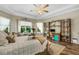 Serene main bedroom featuring tray ceilings, hardwood floors, and a large window offering backyard views at 5329 Trails Bend Ct, Sarasota, FL 34238