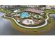 Beautiful aerial view of community pool featuring wading pool, playground, chairs, and lounging areas at 5329 Trails Bend Ct, Sarasota, FL 34238