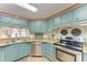 Well-lit kitchen with blue cabinets, stainless steel appliances, and a functional layout at 5619 Bayshore Rd # 423, Palmetto, FL 34221