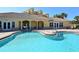 Community pool with covered patio, and clubhouse with french doors, pillars, and lush landscaping at 611 Riviera Dunes Way # 107, Palmetto, FL 34221