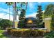 Landscaped community sign for Laguna at Riviera Dunes with blue skies and palm trees in the background at 611 Riviera Dunes Way # 107, Palmetto, FL 34221