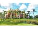 Exterior view of well-maintained condo building overlooking lush green lawn and tranquil pond at 611 Riviera Dunes Way # 107, Palmetto, FL 34221