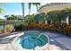 Community hot tub with lush landscaping and an iron fence at 611 Riviera Dunes Way # 107, Palmetto, FL 34221