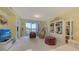Spacious living room featuring neutral walls, sliding glass doors to balcony and a decorative display case at 611 Riviera Dunes Way # 107, Palmetto, FL 34221