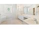Spacious bathroom featuring dual sinks, a bathtub, and decorative wallpaper at 6602 Peach Tree Creek Rd, Bradenton, FL 34203