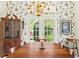 Bright dining room boasts floral wallpaper, classic hutch, and ample natural light at 6602 Peach Tree Creek Rd, Bradenton, FL 34203