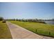 Scenic golf course view with lush green grass, a walking path, and luxury homes in the background near a lake at 6602 Peach Tree Creek Rd, Bradenton, FL 34203