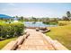 Brick stairs lead to an outdoor seating area with a lake view in the community, with lush landscaping at 6602 Peach Tree Creek Rd, Bradenton, FL 34203
