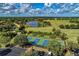 Picturesque aerial shot highlighting tennis courts, a pond, and a beautiful golf course in a lush landscape at 7278 Lismore Ct, Lakewood Ranch, FL 34202