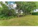 Backyard view features a lush, green lawn with mature trees and shrubbery at 7278 Lismore Ct, Lakewood Ranch, FL 34202