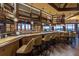 Elegant bar area featuring dark wood finishes, ample seating, and a comprehensive wine and spirits display at 7278 Lismore Ct, Lakewood Ranch, FL 34202