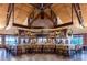 Spacious bar area under wooden beams, stocked with a vast array of wines and comfortable seating at 7278 Lismore Ct, Lakewood Ranch, FL 34202