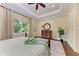 Bedroom featuring tray ceiling, large window, hardwood floors, and an area rug at 7278 Lismore Ct, Lakewood Ranch, FL 34202
