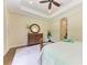 Bedroom featuring tray ceiling, hardwood floors, and a view of the en-suite bathroom at 7278 Lismore Ct, Lakewood Ranch, FL 34202