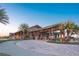 Elegant clubhouse entrance with a covered entryway, palm trees, and lush landscaping at 7278 Lismore Ct, Lakewood Ranch, FL 34202