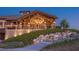 Stunning exterior view of clubhouse featuring a covered patio, stone accents, and picturesque landscaping at 7278 Lismore Ct, Lakewood Ranch, FL 34202