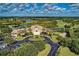 Aerial view of the grand clubhouse with a circular driveway and tropical landscaping at 7278 Lismore Ct, Lakewood Ranch, FL 34202