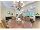 Elegant dining room featuring a wooden table, wicker chairs, and a decorative chandelier at 7278 Lismore Ct, Lakewood Ranch, FL 34202