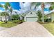 Charming single-story home featuring a brick driveway, lush landscaping, and a two-car garage at 7278 Lismore Ct, Lakewood Ranch, FL 34202
