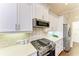 Modern kitchen featuring white cabinets, stainless steel appliances, and stylish backsplash at 7278 Lismore Ct, Lakewood Ranch, FL 34202