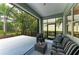 The screened patio features wicker furniture with a view to the lush backyard at 7278 Lismore Ct, Lakewood Ranch, FL 34202