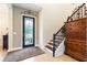 Foyer featuring a decorative glass front door, staircase with dark banister, and wooden furniture at 750 116Th Ne Ct, Bradenton, FL 34212