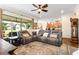 Open living room featuring a leather sectional, ceiling fan, and view of the backyard and updated kitchen at 750 116Th Ne Ct, Bradenton, FL 34212
