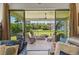 View of the screened-in patio with comfortable seating and backyard views from the living room at 750 116Th Ne Ct, Bradenton, FL 34212