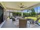 Relaxing screened-in patio with comfortable seating, ceiling fan, and views of the lush backyard at 750 116Th Ne Ct, Bradenton, FL 34212